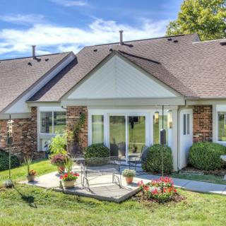 A charming residential house with a landscaped yard and patio.