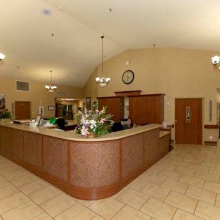 A spacious reception area with a counter and flower arrangement.