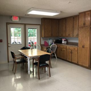 A kitchen area with wooden cabinets, a table, and chairs.