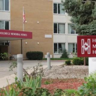 Entrance of a hospital building with signage and landscaping.