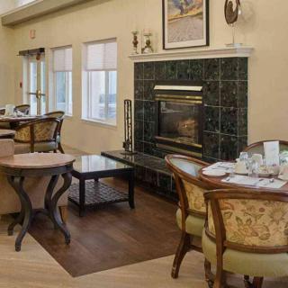 A cozy dining room with elegant furnishings and a fireplace.