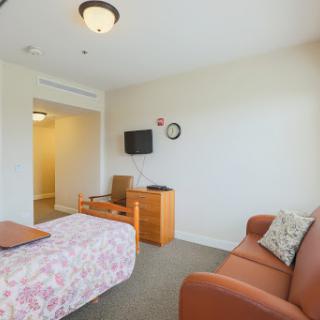 A cozy interior showcasing a well-furnished room with a bed, sofa, and television.
