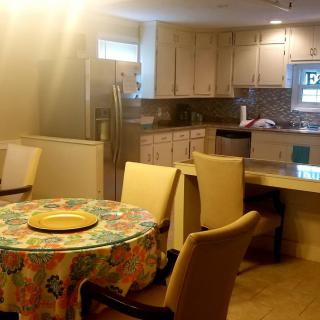 A cozy kitchen and dining area with a round table covered in a colorful tablecloth.