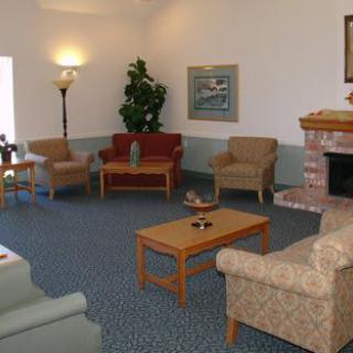 A cozy living room with sofas, chairs, a coffee table, and a fireplace.