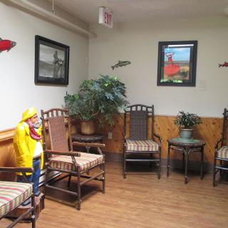 A cozy waiting room with wooden chairs and plants.