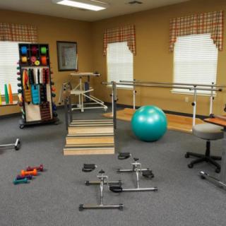A physical therapy room with various rehabilitation and exercise equipment.
