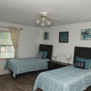 A cozy bedroom with two twin beds, featuring elegant decor and soft lighting.