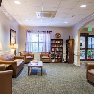 A cozy lobby area with comfortable seating and a bookshelf.