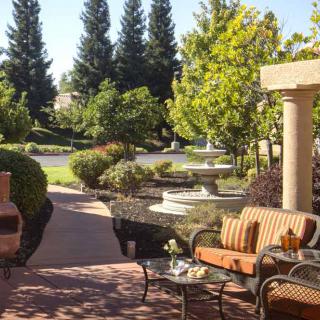 A tranquil garden with comfortable outdoor seating and a fountain.