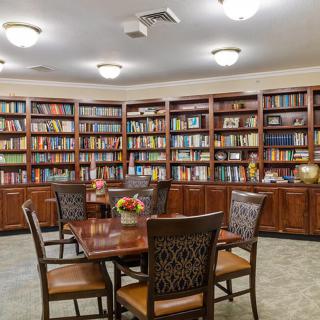 A cozy library with wooden bookshelves and a seating area.