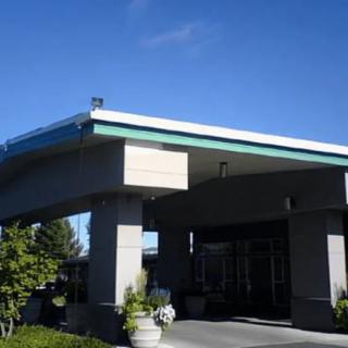 A building entrance with a covered walkway under a clear blue sky.