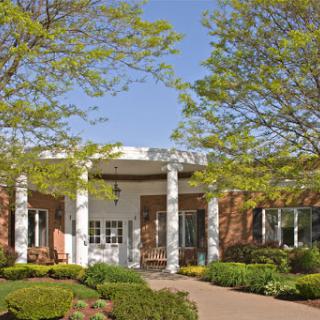 A welcoming front view of a modern building surrounded by lush greenery.