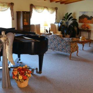 A cozy living room featuring a grand piano and elegant decor.