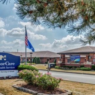 A healthcare facility with an entrance sign and flag displayed outside.