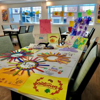 A table adorned with colorful handmade art and craft projects in a bright room.