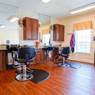 A bright and welcoming barbershop interior with styling chairs and mirrors.