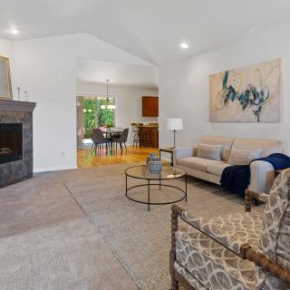 A modern living room featuring a comfortable sofa, stylish coffee table, and fireplace, complemented by artwork on the wall.