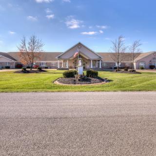 A suburban residential building with a well-maintained lawn and clear blue skies.