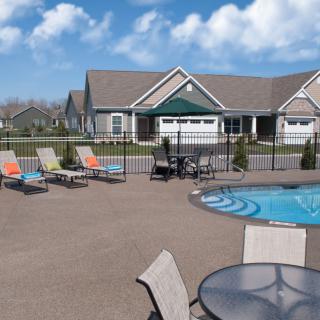 A suburban residential area featuring an outdoor swimming pool and patio furniture.