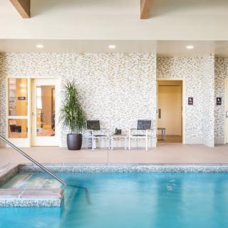 A serene indoor pool area with adjacent seating and modern decor.