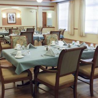 An elegantly set dining room with tables and chairs arranged neatly.