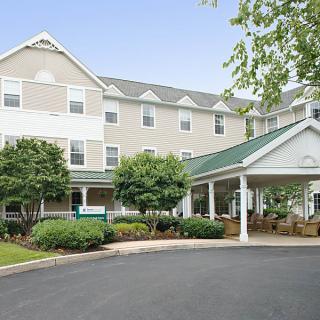 The exterior view of a hotel with a covered entrance and landscaped surroundings.