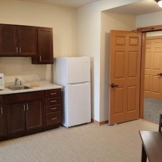 A cozy kitchen space featuring wooden cabinets, a refrigerator, and an inviting atmosphere.