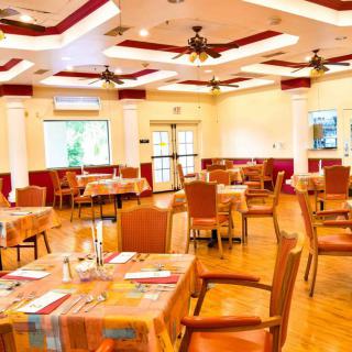 An inviting, well-lit restaurant dining area with neatly arranged tables and chairs.
