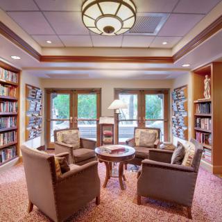 A cozy reading nook in a library with comfortable chairs and bookshelves.