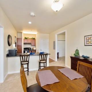 A cozy dining area with a round table and a view into the kitchen.