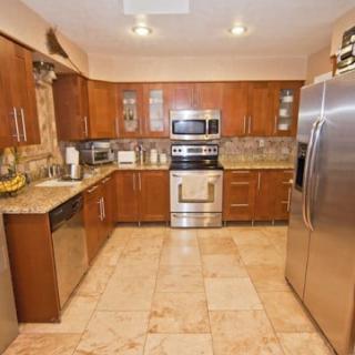 A modern kitchen with stainless steel appliances and wooden cabinets.