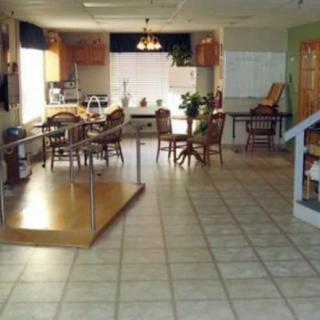 A spacious kitchen and dining area with tile flooring, wooden furniture, and ample natural light.