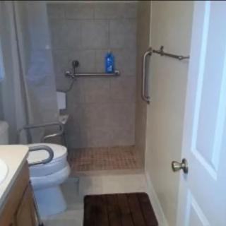 A modern bathroom with a shower, toilet, and sink area.