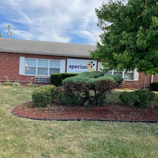 A brick building with landscaping and a visible sign.