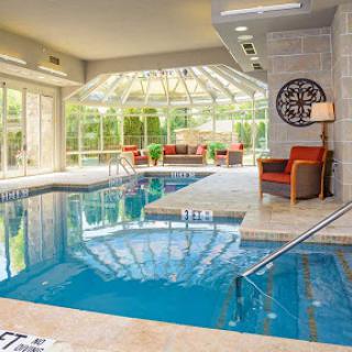 A serene indoor pool area with ample natural light, perfect for relaxation and leisure.