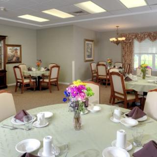 A well-decorated dining room with elegant table settings and floral centerpieces.