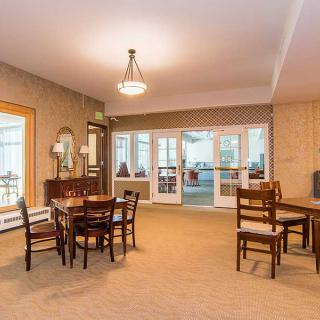 A well-lit interior dining area featuring tables and chairs, with a mirror and decor on the wall.