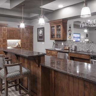 A modern home bar with wood cabinetry and stylish lighting.