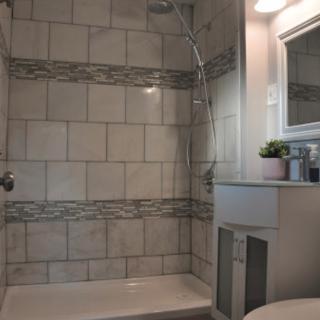A modern bathroom with tiled walls and a shower area.