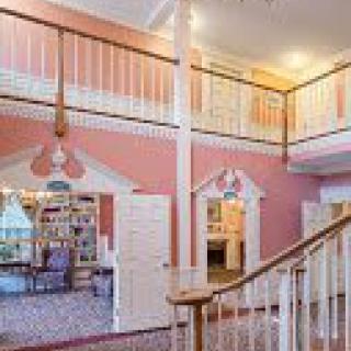 A whimsically decorated children's area with pastel colors and a large staircase.