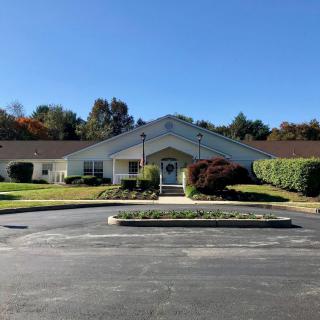 A suburban building surrounded by greenery under a clear blue sky.