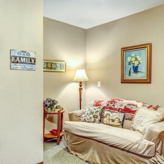 A cozy living room corner with a sofa, decorative pillows, and a floor lamp.