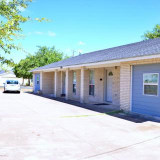 A row of residential houses with a driveway and a parked vehicle.