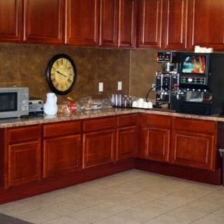 A kitchen area with wooden cabinets, a coffee machine, and a microwave.