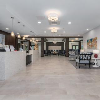 A modern lobby with a reception desk and cozy seating areas.