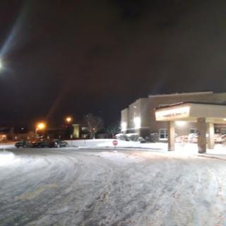 A snowy scene at night with a well-lit building in the foreground.