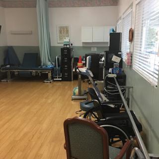 A rehabilitation therapy room featuring exercise equipment and seating.