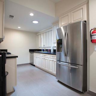 A modern kitchen featuring stainless steel appliances and white cabinetry.