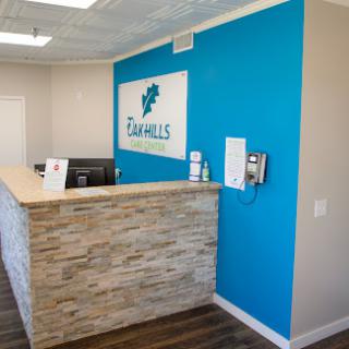 A modern office reception area featuring a blue accent wall and a stylish wooden front desk.