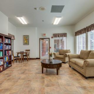 A cozy living room with bookshelves, a comfortable sofa set, and a central coffee table, offering a welcoming space for relaxation and reading.